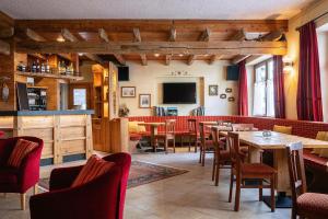 a restaurant with tables and chairs and a television at Hotel Funivia in Chiesa in Valmalenco