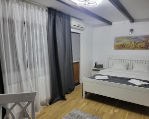 a bedroom with a bed and a window at Retro House in Pantelimon