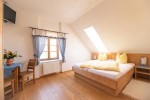 a bedroom with a bed and a desk and a window at Frühstückspension Kleinschuster in Burgau