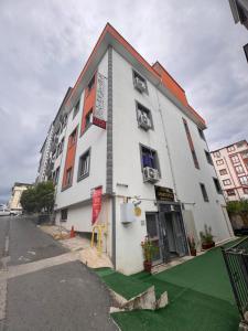 a white building on a street with green grass at miamia apart otel in Trabzon