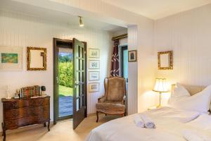 a bedroom with a bed and a chair and a window at Villa Mona Lisa in Seefeld in Tirol