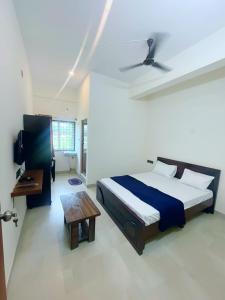 a bedroom with a bed and a table in it at GR Comforts Boarding and Lodging in Hirehalli