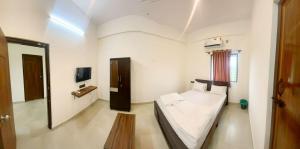 a small room with a bed and a tv at GR Comforts Boarding and Lodging in Hirehalli +6 photos