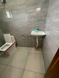 a bathroom with a sink and a toilet at GR Comforts Boarding and Lodging in Hirehalli