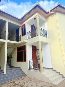 a white house with red doors and balconies at Lunora Homes in Arusha