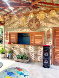 a building with a brick wall with a stove at Loft Verde - Pousada Vila Dondom in Luis Correia