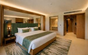 a large bedroom with a large bed with a green wall at The Crown Puducherry in Pondicherry +20 photos