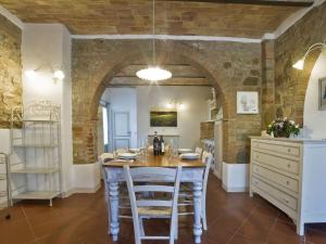 a dining room with a table and a brick wall at Apartment Torrenieri by Interhome in Vergelle
