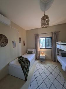 a bedroom with two beds and a window at Ka Nicita - Beach house with pool in Praia de Macaneta