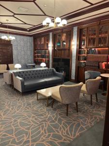 a library with a couch and chairs and books at The Newgrange Hotel in Navan