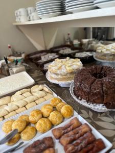 a table topped with different types of pastries and cakes at ACOMODARE HOTEL- SOB NOVA Direção in Tubarão