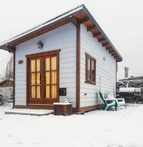 a small house with two chairs in the snow at My little big house in Dina Huapi +2 photos