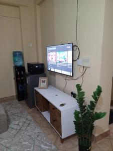 a living room with a tv on a wall at Voi town CBD homes in Voi +1 photo