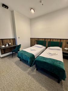 a room with two beds and a desk in it at Hotel&Restauracja Zamek Bytów in Bytów