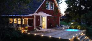 a wooden deck with an umbrella and a swimming pool at Landhaus Måsberget in Kristinehamn