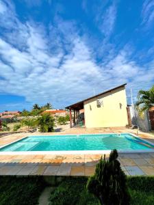 a swimming pool in front of a house at Loft Verde - Pousada Vila Dondom in Luis Correia