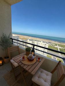 a table and chairs on a balcony with a view of the beach at Sumgait Boulevard View Apartment in Sumqayıt