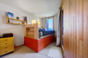 a bedroom with a bed and a dresser and a window at Grand studio Cosy divisible in Valmorel