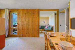 a living room with a table and a couch at Grand studio Cosy divisible in Valmorel
