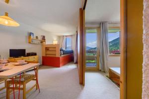 a room with a desk and a bedroom with a window at Grand studio Cosy divisible in Valmorel