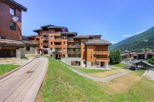 a large building on a hill next to a road at Grand studio Cosy divisible in Valmorel