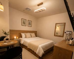 a bedroom with a bed and a table and a mirror at 힐링모텔 in Inch'ŏn-yŏk