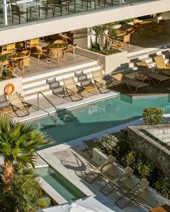 an overhead view of a hotel pool with chairs and tables at Divani Corfu Palace in Corfu +32 photos