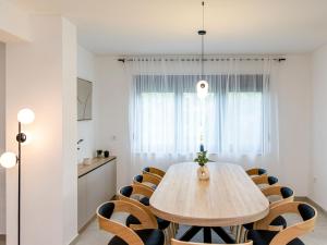 a dining room with a wooden table and chairs at Villa Antica by Interhome in Lopar