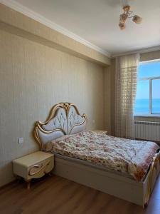 a bedroom with a large bed with a large window at Sumgait Boulevard View Apartment in Sumqayıt