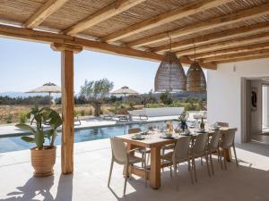 a dining room with a table and chairs and a pool at Villa Bema - Quietness and Beach access in Molos Parou