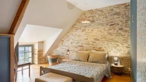 a bedroom with a bed and a stone wall at Gite champêtre in Tréal