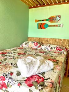 a bedroom with a bed with a floral comforter at Loft Verde - Pousada Vila Dondom in Luis Correia +16 photos
