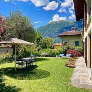 a garden with a table and chairs and an umbrella at Casa Lory in Bellagio