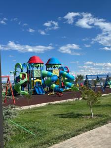 a playground with a water slide in a park at Ademi cottage in Koshkolʼ
