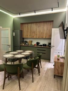 a kitchen with a table and chairs in a kitchen at Ademi cottage in Koshkolʼ