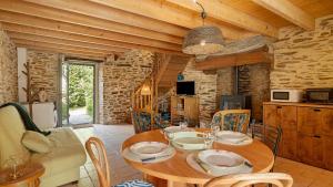 a dining room with a wooden table and chairs at Gite champêtre in Tréal