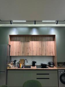 a kitchen with wooden cabinets and a counter top at Ademi cottage in Koshkolʼ +5 photos