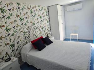 a bedroom with a white bed with red pillows on it at En Resort Fincas Las Dunas dos Chalets con jacuzzis en primera linea de playa , uno de 4 dormitorios y otro de 2 dormitorios, Llama al Seiscientos veintisiete Cuatrocientos diecisiete Trescientos noventa y ocho in Rota