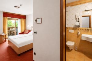 a hotel room with a bed and a bathroom at Terme Banovci - Hotel Zeleni Gaj in Banovci