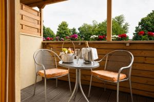 a table and chairs on a balcony with a window at Terme Banovci - Hotel Zeleni Gaj in Banovci
