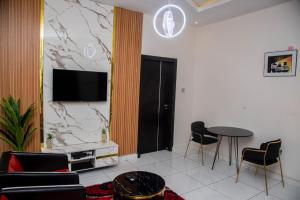 a living room with a table and chairs and a tv at Pretelia Hotel in Warri