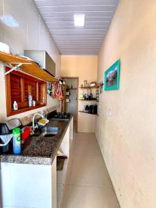 a kitchen with a sink and a counter top at Loft Rosa - Pousada Vila Dondom in Luis Correia