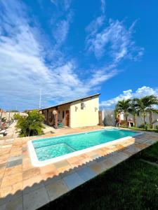 a swimming pool in front of a house at Loft Rosa - Pousada Vila Dondom in Luis Correia