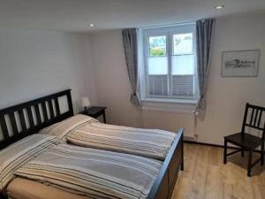 a bedroom with a large bed and a window at Le Pélerin in Saignelégier