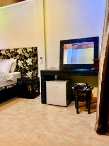 a bedroom with a bed and a mirror and a table at Ferme Oasis de Fes in Fez