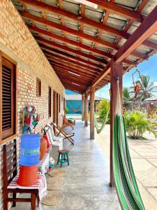 a porch with a hammock on a house at Loft Azul - Pousada Vila Dondom in Luis Correia