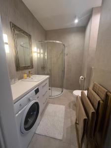 a bathroom with a washing machine and a shower at Apartament indyjski Legnica in Legnica
