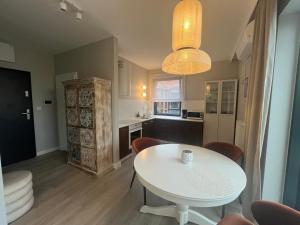 a kitchen and dining room with a white table at Apartament indyjski Legnica in Legnica +3 photos