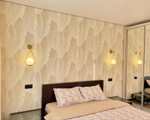 a bedroom with a bed and a wall with feathers at Jacuzzi With light Nauki Avene in Kharkiv