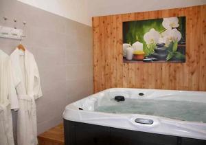 a bathroom with a tub with a painting on the wall at La Grange de Jeanne in Moosch